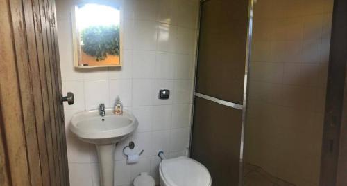 a small bathroom with a sink and a toilet at Pousada Allmar in Bertioga