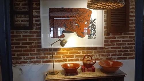 a painting of a tiger on a wall with bowls on a table at Virgínia Palace in Corumbá