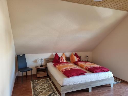 a bedroom with a bed with red and orange pillows at Zschirnsteinblick in Schöna
