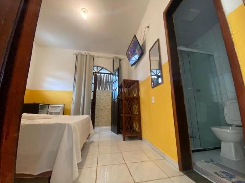 a bathroom with a bed and a toilet in a room at Pousada Sol E Mar in Morro de São Paulo