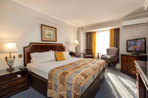 a hotel room with a bed and a television at Park Plaza Santiago in Santiago