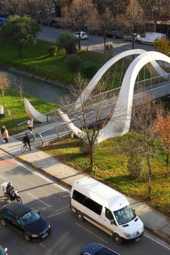 a white van driving down a street with a bridge at Terra Boutique Hotel in Tirana