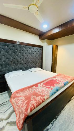 a bedroom with a large bed with a padded headboard at Arbuda inn in Mount Ābu