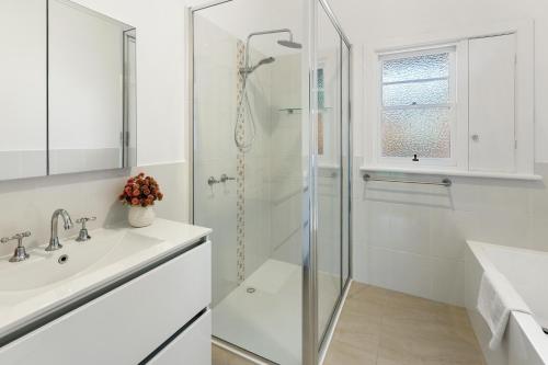 a white bathroom with a shower and a sink at Nan's House in Mansfield