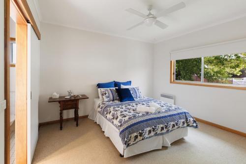 a bedroom with a bed with blue pillows and a window at Nan's House in Mansfield
