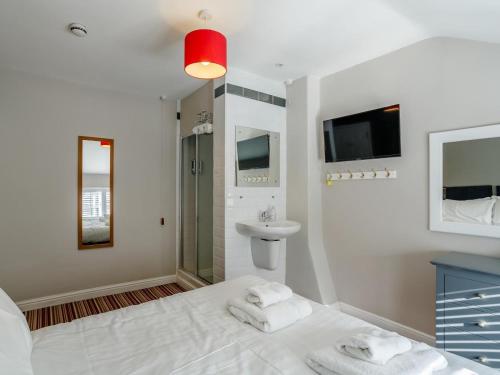 a white bedroom with a sink and a bed with towels at 4 Bed in Harrogate oc-hh025 in Harrogate