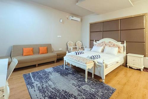 a large bedroom with a bed and a couch at Privates Strandhaus auf den Malediven in Kudafari