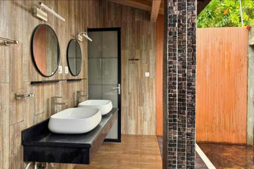 a bathroom with two sinks and a mirror at Privates Strandhaus auf den Malediven in Kudafari