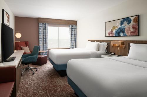 a hotel room with two beds and a television at Hilton Garden Inn Virginia Beach Town Center in Virginia Beach