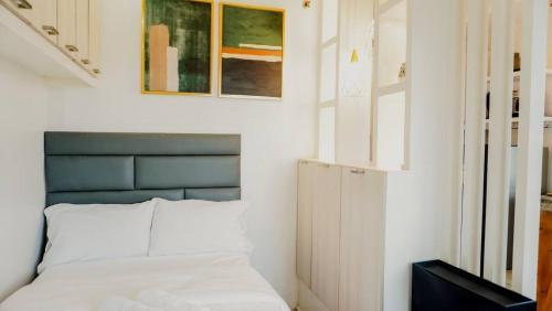 a bedroom with a bed and paintings on the wall at Corner Studio w Wi-Fi CasaMira Labangon in Cebu City