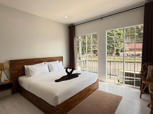 a bedroom with a bed and a large window at Chailai room202 in Ban Sai Thai