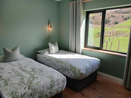 two beds in a room with a window at Mountain hideaway in Finny
