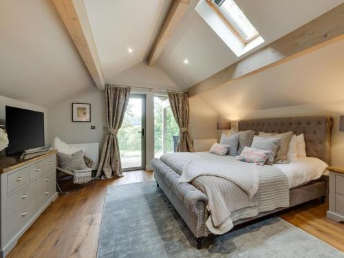 a bedroom with a large bed and a skylight at 3 Bed in Otley oc-g0176 in Timble