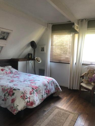 a bedroom with a bed and a window and a chair at Woodune in Neufchâtel-Hardelot