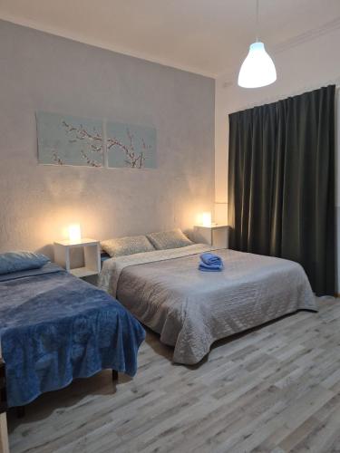 ein Schlafzimmer mit zwei Betten, zwei Lampen und einem Fenster in der Unterkunft Milner Flats in Sliema