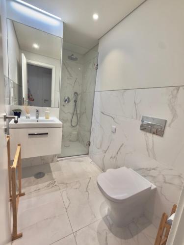 a bathroom with a toilet and a sink and a shower at Suíte aconchegante in Lisbon
