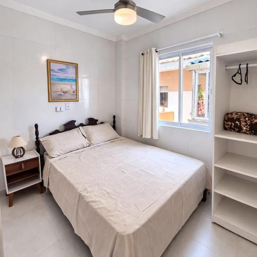 a white bedroom with a bed and a window at Apartlaguna Prime in Laguna
