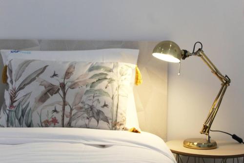 a bed with a pillow and a lamp on a table at Valbom Hideaway Light, Style and Peace in Valbom