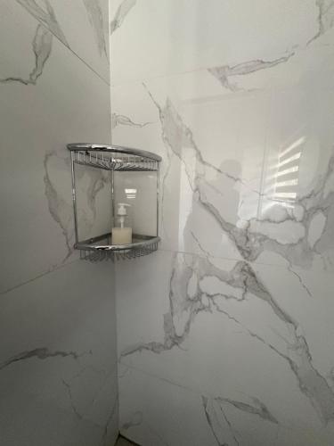 a bathroom with a white marble wall with a shelf at Unit 7-9 at Homely Escapes in Phalaborwa