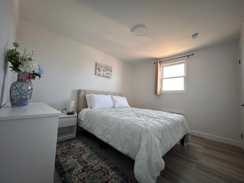 a bedroom with a bed and a vase of flowers at Bridge View near Confederation Bridge and beaches in Borden-Carleton