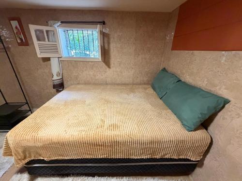 a small bed in a small room with a window at Cantinho do Imperador in Petrópolis