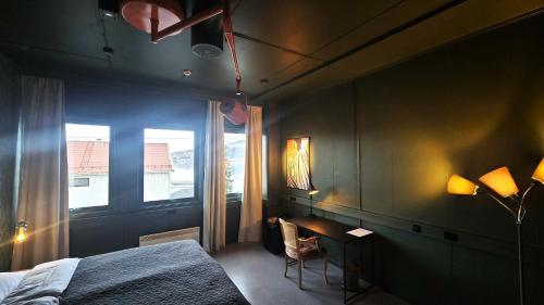 a bedroom with a bed and a desk and a window at Kuben Utleie in Narvik