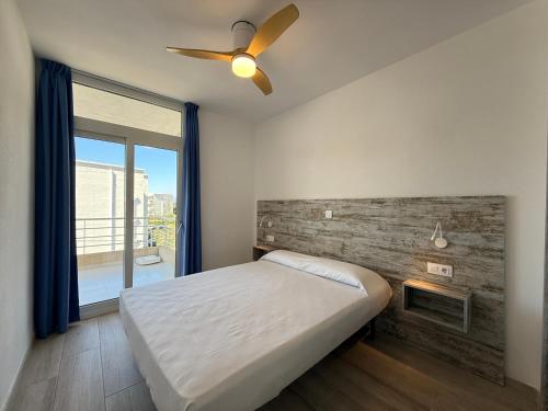 a bedroom with a bed and a ceiling fan at Agi Rescator Apartments in Roses