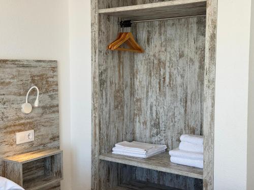 a bathroom with a wooden wall with towels on a shelf at Agi Rescator Apartments in Roses