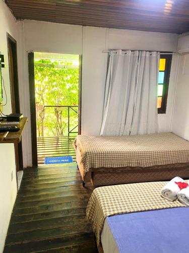 a bedroom with two beds and a window with a view at Pousada Boldró Home in Fernando de Noronha