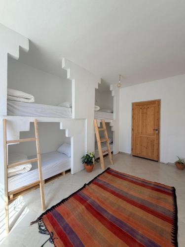 a room with two bunk beds and a rug at Hakuna Matata Guest House in Tamraght Ouzdar