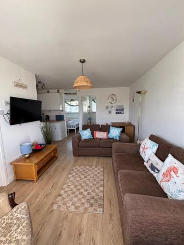a living room with two couches and a tv at 288, Two bed Chalet on Belle Aire Holiday Park - With private veranda, sleeps 5, pet friendly, free Wi-Fi, bed linen and towels included and onsite entertainment available in Hemsby
