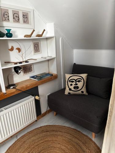 a small living room with a couch and a pillow at Maison d'hôtes des Mondfänger in Meisenthal