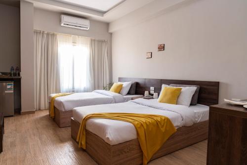 a hotel room with two beds with yellow sheets at Al Dora Hotel & Spa in Hurghada