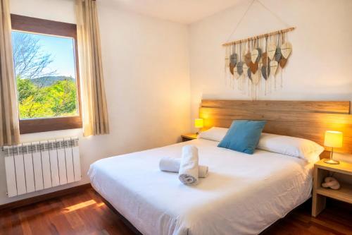 a bedroom with a large white bed with a window at Allotjaments Pirineus in Molló