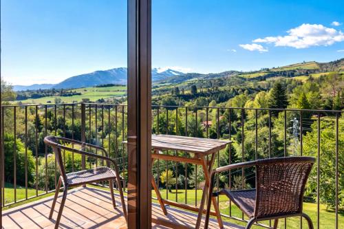 a table and two chairs on a balcony with a view at Allotjaments Pirineus in Molló