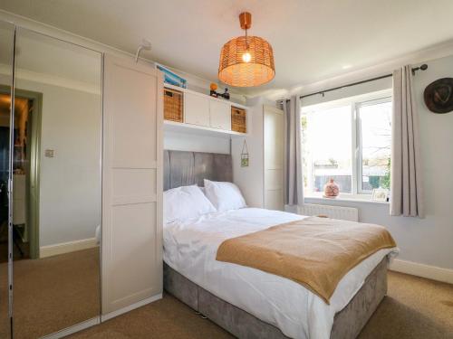 a bedroom with a bed and a large window at Farnham Park Apartment in Farnham