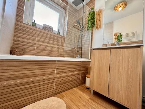 a bathroom with a shower and a sink and a window at Le Nid Doré in Calais