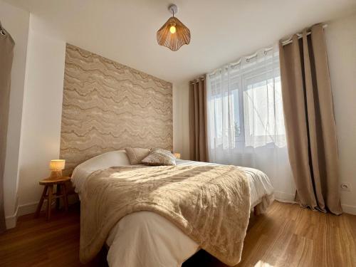 a bedroom with a bed and a large window at Le Nid Doré in Calais