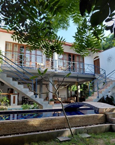a house with a staircase and a swimming pool at Villa Mosaic in Tangalle