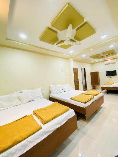 a bedroom with two beds and a ceiling fan at Vishwa Heritage Ellora in Ellora