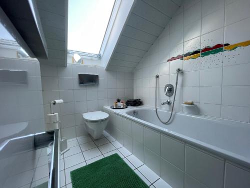 a bathroom with a tub and a toilet and a sink at Altrhein Hideaway ruhige Ferienwohnung nahe Frankfurt ideal für Natur & Radfahrer in Riedstadt