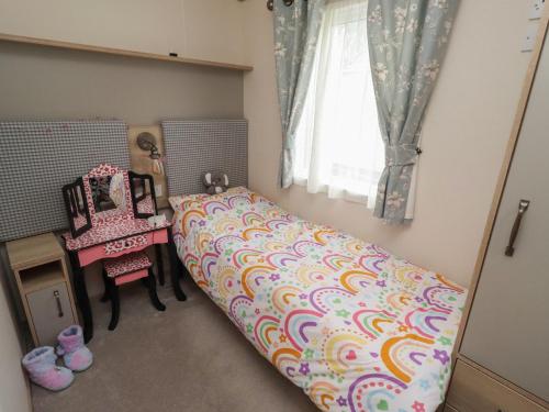 a bedroom with a bed and a table and a window at Cresswell Towers in Morpeth