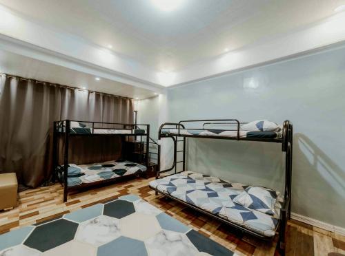a room with two bunk beds and a rug at Jhenk's Guesthouse in Coleto