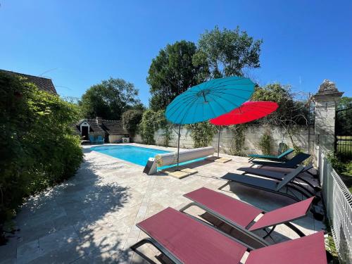 a group of chairs and umbrellas next to a swimming pool at La mare aux bambous in Couffy