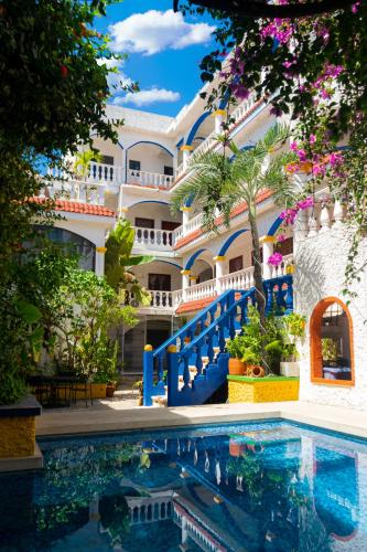 a resort with a swimming pool in front of a building at Villa Madre by La Cultura Suites - Hotel Moms in Playa del Carmen