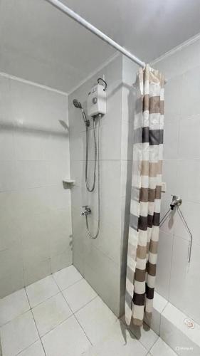 a shower with a shower curtain in a bathroom at Kurt Condo Rental Simple & Cozy in Piapi