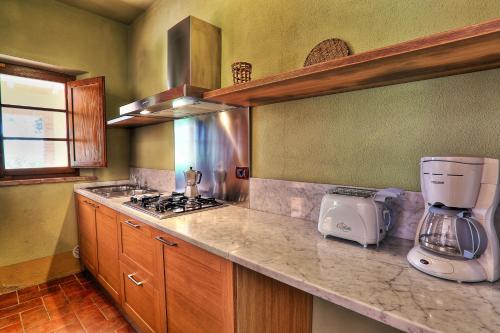 a kitchen with a coffee maker on a counter at Relais Poggio al Vento in Pomarance