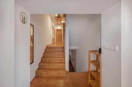 a staircase in a house with white walls and wooden floors at Tatry TOP Dom in Vavrišovo