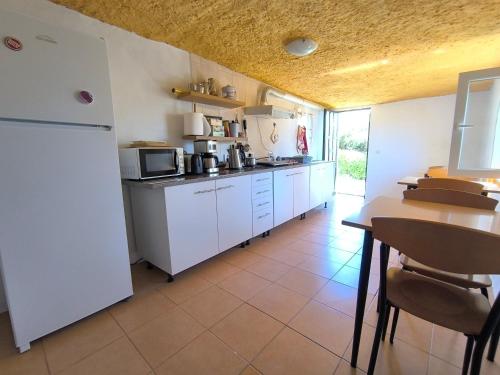 a kitchen with a white refrigerator and a table at Vivenda Familia Pedro in Vila do Bispo