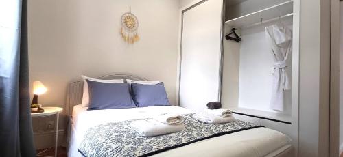 a bedroom with a bed with blue pillows and a mirror at 1000Jo Apartment T3 in Gulpilhares